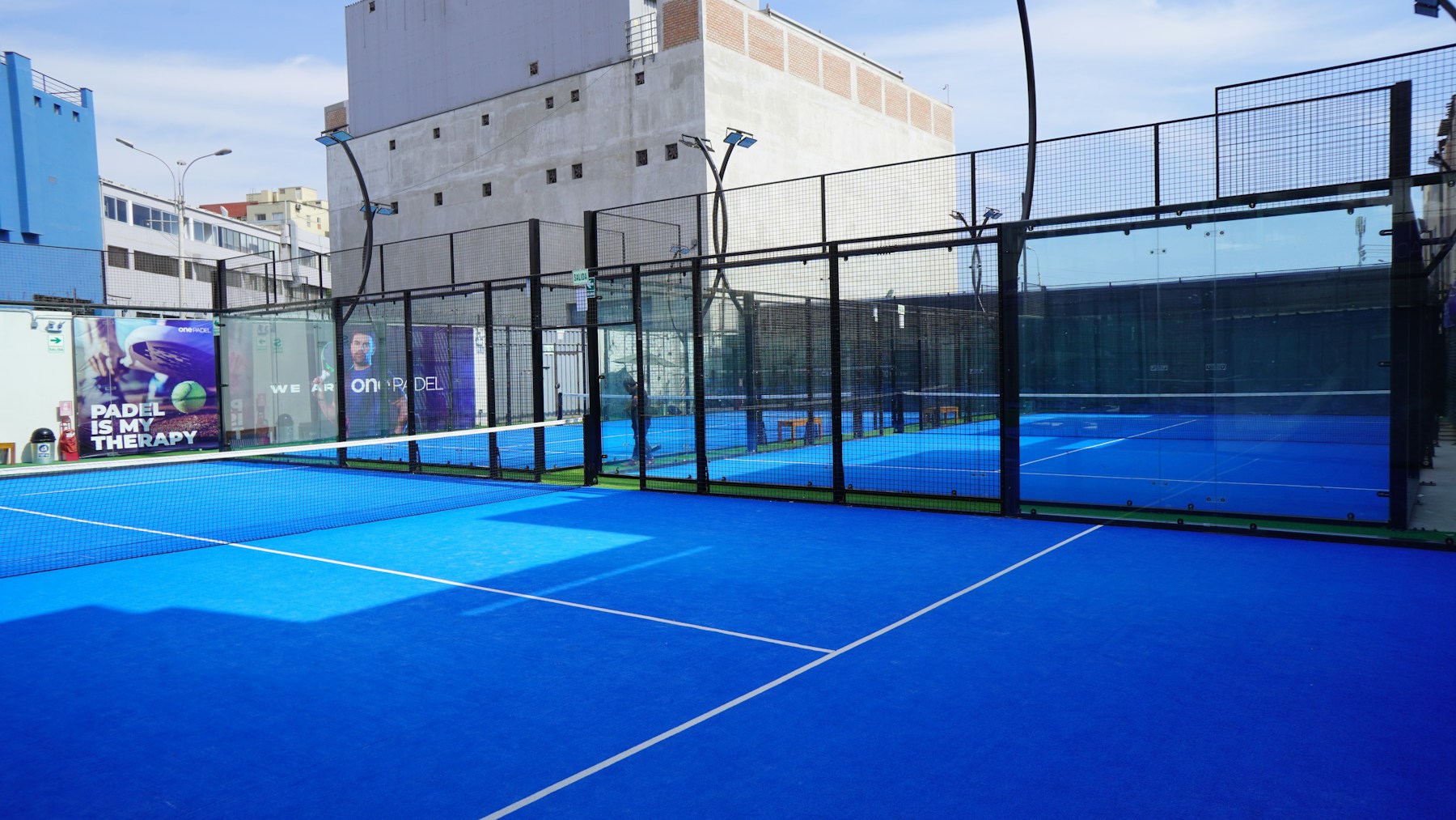 Lege blauwe padelbaan met glazen wanden