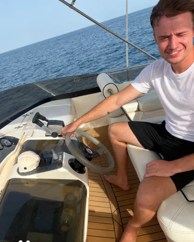Ruben Oud aan het roer van een boot op zee